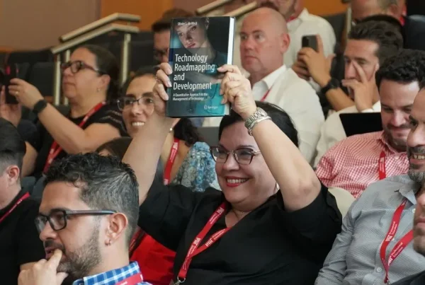 MIT Professional Education participant holding a Technology Roadmapping and Development book during an in-person session